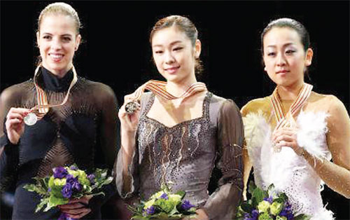피겨여왕 김연아가 16일 온주 런던 버드와이저 가든스에서 열린 2013 국제빙상경기연맹(ISU) 세계선수권대회 우승을 차지한 후 금메달을 들어보이고 있다. 2위는 카롤리나 코스트너(왼쪽), 3위는 아사다 마오.