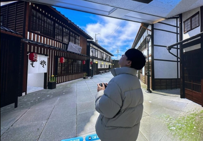 이머시브큐브에서 HMD(헤드셋) 없이 경북 포항 구룡포 일본인 가옥거리를 구현한 XR 콘텐츠를 체험하는 모습 (사진 WPRHD=올림플래닛) [출처:중앙일보] 
