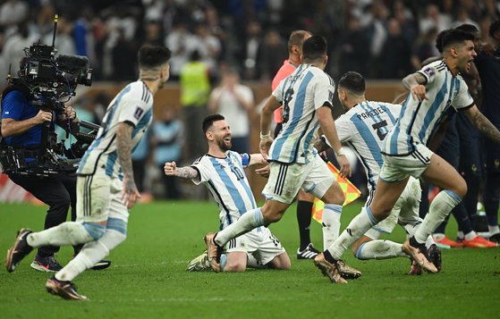 리오넬 메시(가운데)가 오랜 꿈이던 아르헨티나의 월드컵 우승이 확정된 순간, 그라운드에 무릎을 꿇으며 환호하고 있다. [로이터=연합뉴스]